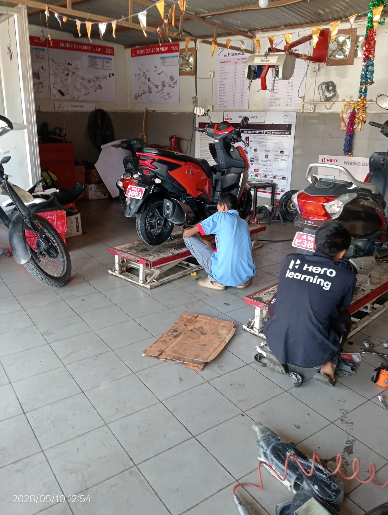 Mechanics servicing motorcycles in Dipshikha's workshop